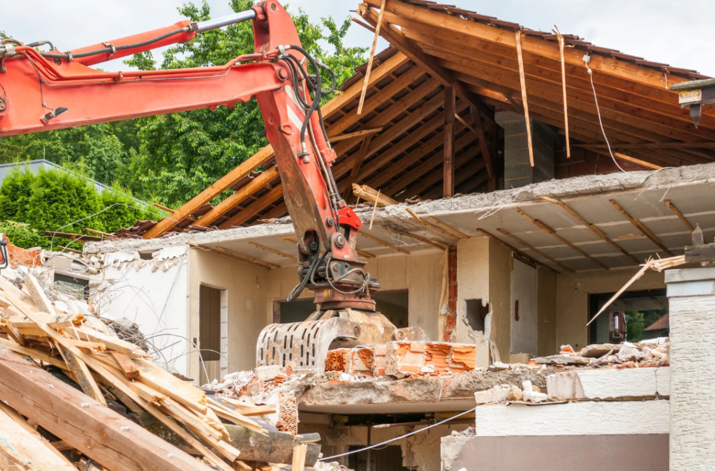 Excavator demolishing a house during a debris removal job